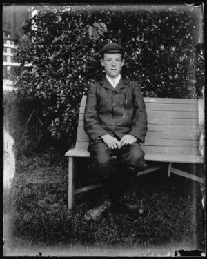 Young man sitting on a garden bench