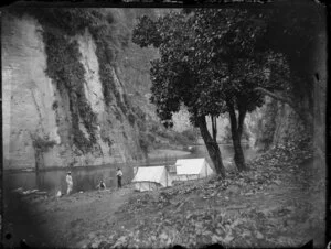 Unidentified men at campsite beside river, Whanganui