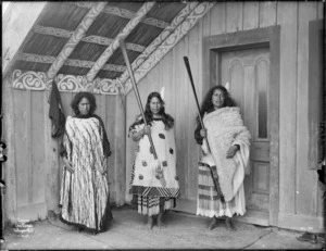 Three unidentified Maori women from Ngai Tuhoe with cloaks and taiaha