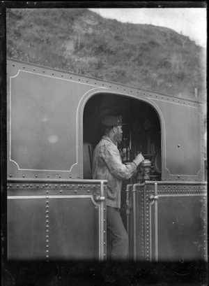 Man at the controls of a steam locomotive.