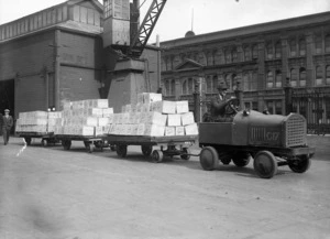 Man in a vehicle, pulling 3 trailor loads of butter, Wellington wharves