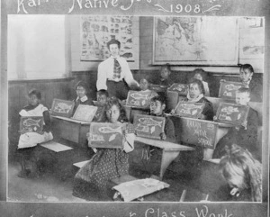 A group of children at Karioi School holding their drawings towards the camera