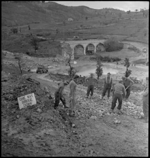 Kaye, George, 1914- (Photographer) : Demolished bridge and World War 2 New Zealand soldiers working on an alternative road, at Sangro River, Italy