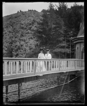 Two women on the bridge to the water outlet control tower at Karori reservoir