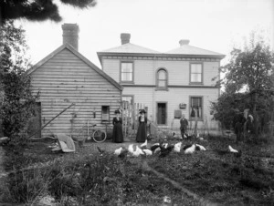 Backyard scene showing people and chickens outside a house