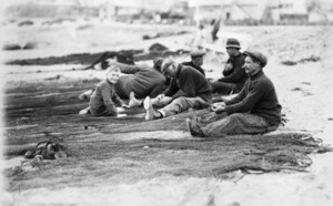 Five fishermen sitting on a beach, with a young boy, Peter Tait