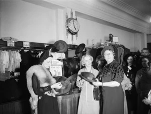 Women next to a hat stand, in a department store