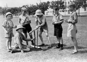 Group of boys, one of whom is hammering in cricket stumps