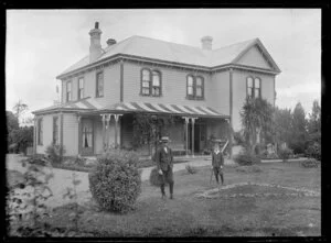 Portrait of two boys and a large house