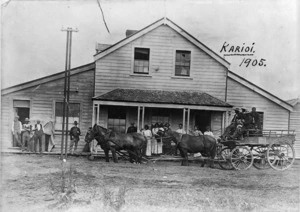 Group and horse drawn cart outside a building in Karioi