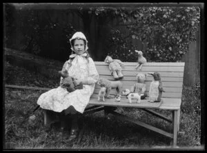 Janet Atkinson sitting on a garden bench with her toys