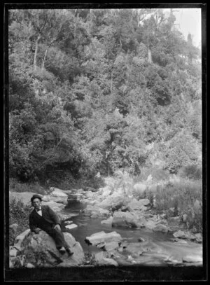 Robert Francis Nicol leaning on a river bank stone