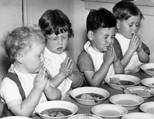 Children saying grace before eating