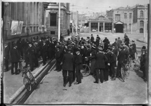 Men gathered in a street to look at Evening News war maps, Christchurch