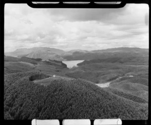 Forestry hut on a hilltop surrounded by pine forest with Green Lake (Lake Rotokakahi) and Mt Tarawera beyond, Rotorua District, Bay of Plenty Region