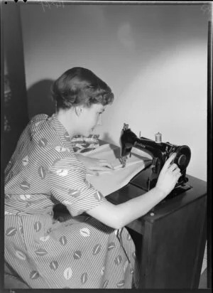 Model demonstrating Peerless sewing machine