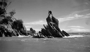 Man standing on a rock formation at Wainui, Golden Bay