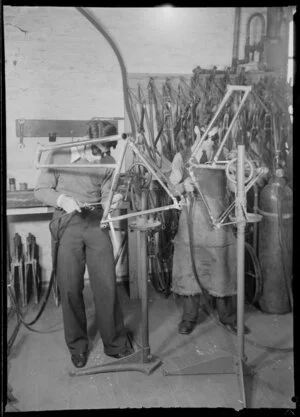 Factory workers welding metal frames