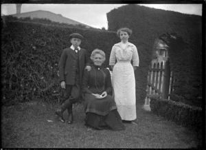 Two unidentified women and a boy in a garden.