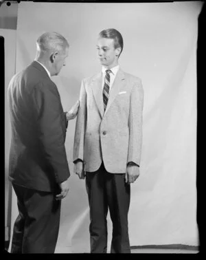 Man [Barry Hill?] modelling sports coat, with Ken Niven in shot