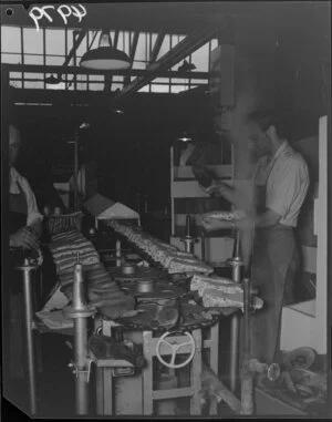 Man gluing soles to slippers at Buchanan and Edwards shoe factory