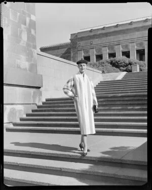 Woman modelling striped coat & beret outside Dominion Museum