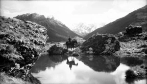 Man seated on a horse by a pond in Rees Valley, Otago