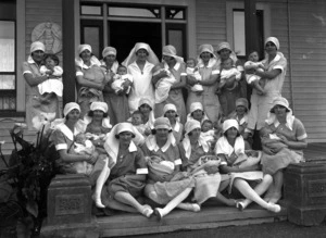 Group of Karitane nurses holding babies and toddlers, Karitane Hospital, Wanganui
