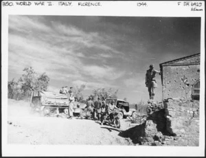 Scene during the advance towards Florence, Italy, during World War II showing a member of New Zealand Provost Corps directing traffic - Photograph taken by George Kaye