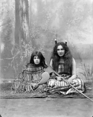 Studio portrait of two young women wearing traditional Maori clothing - Photographed by William Henry Thomas Partington