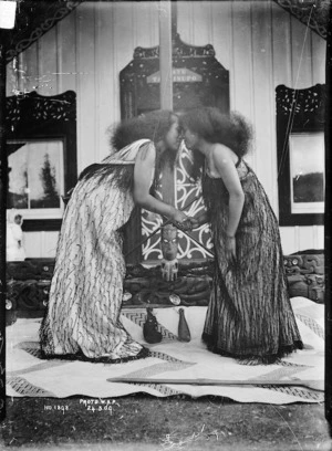 Two unidentified Maori women greeting each other with a hongi