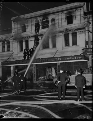 Firemen putting out fire at Smith and Smith Ltd, Cuba Street, Wellington
