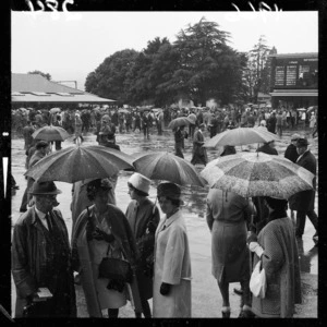 Groups of race-goers standing in rain, Trentham