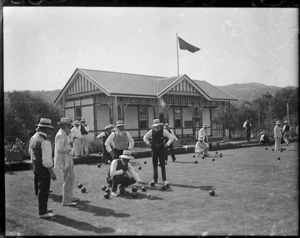 Men playing lawn bowls, and club house