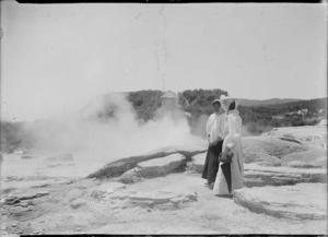Woman and guide beside a geyser, Whakarewarewa