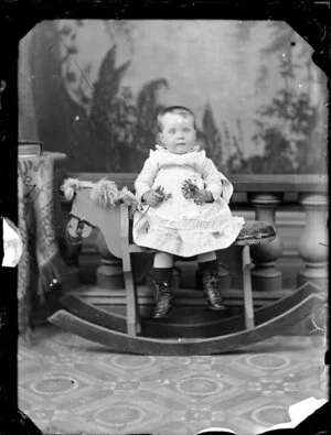 Unidentified baby on rocking horse