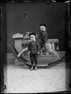 Two unidentified boys and rocking horse