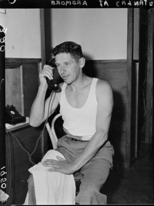 Stan Lay talking on the telephone, 1950 British Empire Games village, Ardmore