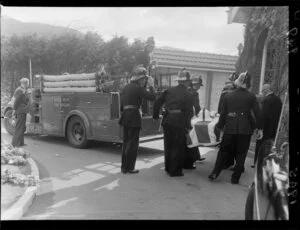The coffin of an Upper Hutt firefighter is carried into a chruch by his collegues, including an Upper Hutt Fire Brigade fire engine