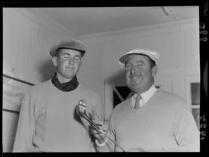 Golfer Bobby Locke (South Africa) holds a golf club as New Zealand golfer Bob Charles looks on, Miramar Golf Course, Wellington