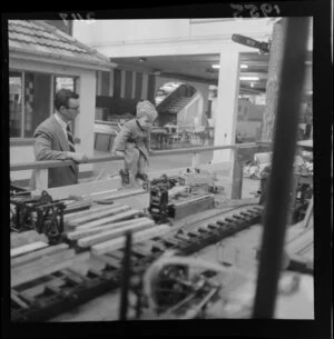 Unidentified man and boy looking at an exhibit at the Diamond Jubilee Exhibition, industrial fair, Petone, Lower Hutt City