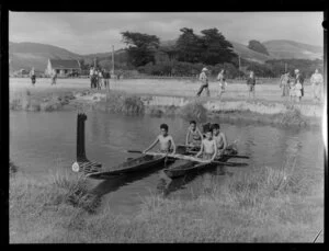 Maori boys in canoes enacting Pauatahaanui settler arrival, in piupiu