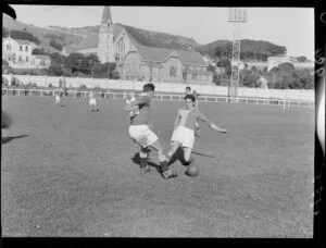 Player makes tackle during soccer game between University and Seatoun teams