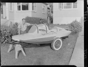 'Speedboat built by deaf and dumb boy' (caption), shown on a trailer by an adult, the boat named as 'Deaf boy'