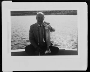 Man holding trout by lake