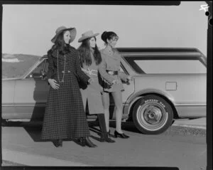 Three female models posing next to car with Dunlop C49