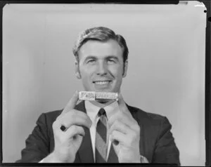 Portrait of man in suit holding packet of Sparkles lollies