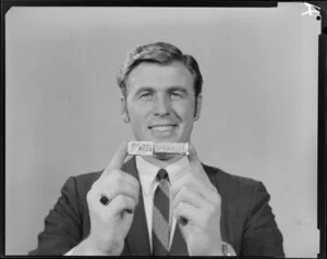 Portrait of man in suit holding packet of Sparkles lollies