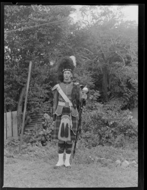 R J Binning, the youngest Drum Major in the City of Wellington's Pipe Band, dressed in his tartan uniform and holding his mace