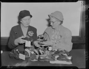 Mrs V J Innes with Miss H S B Lusk and a collection of children's shoes